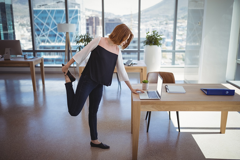 Attentive executive using laptop while exercising in office